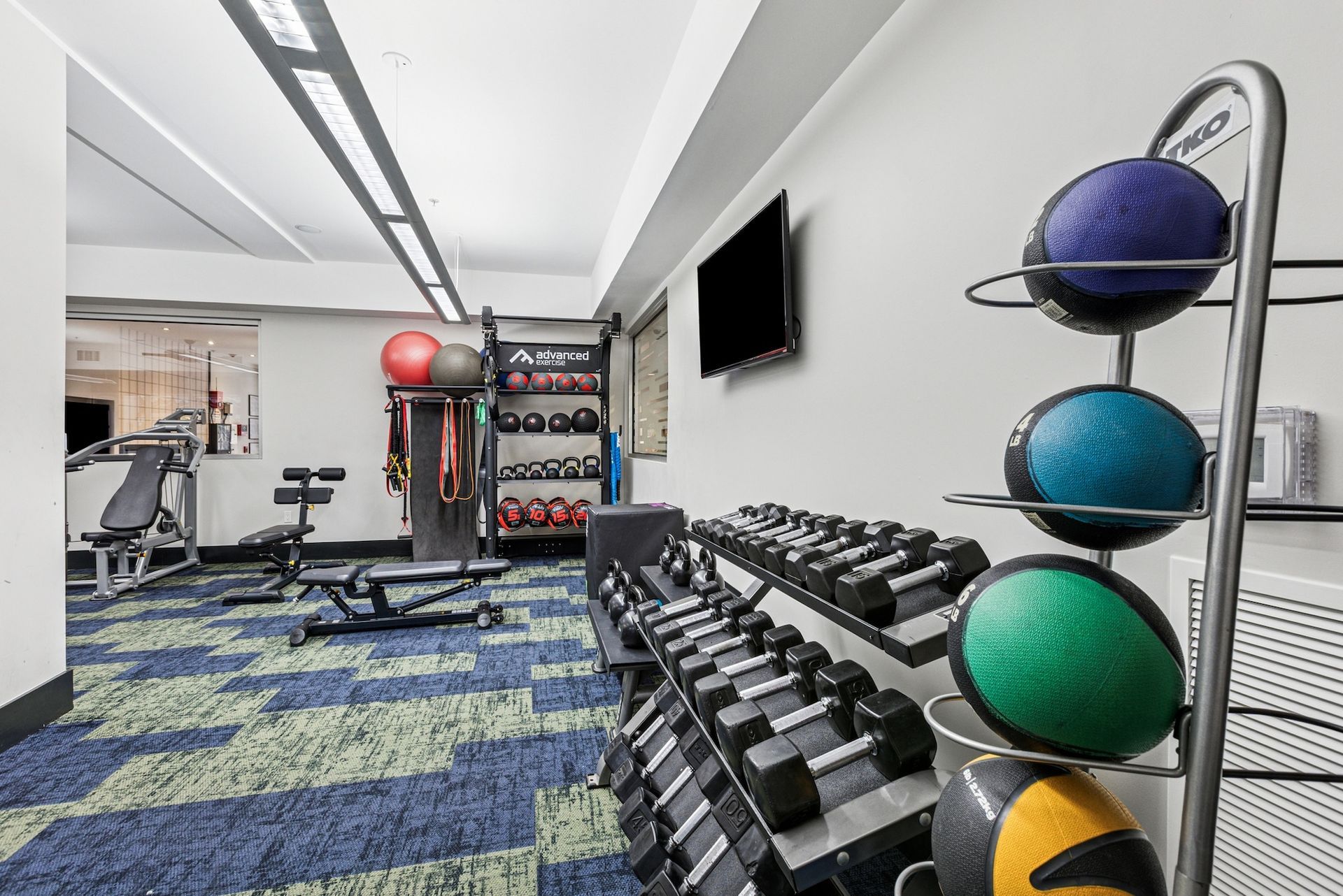 Gym interior with weights, medicine balls, and exercise equipment.