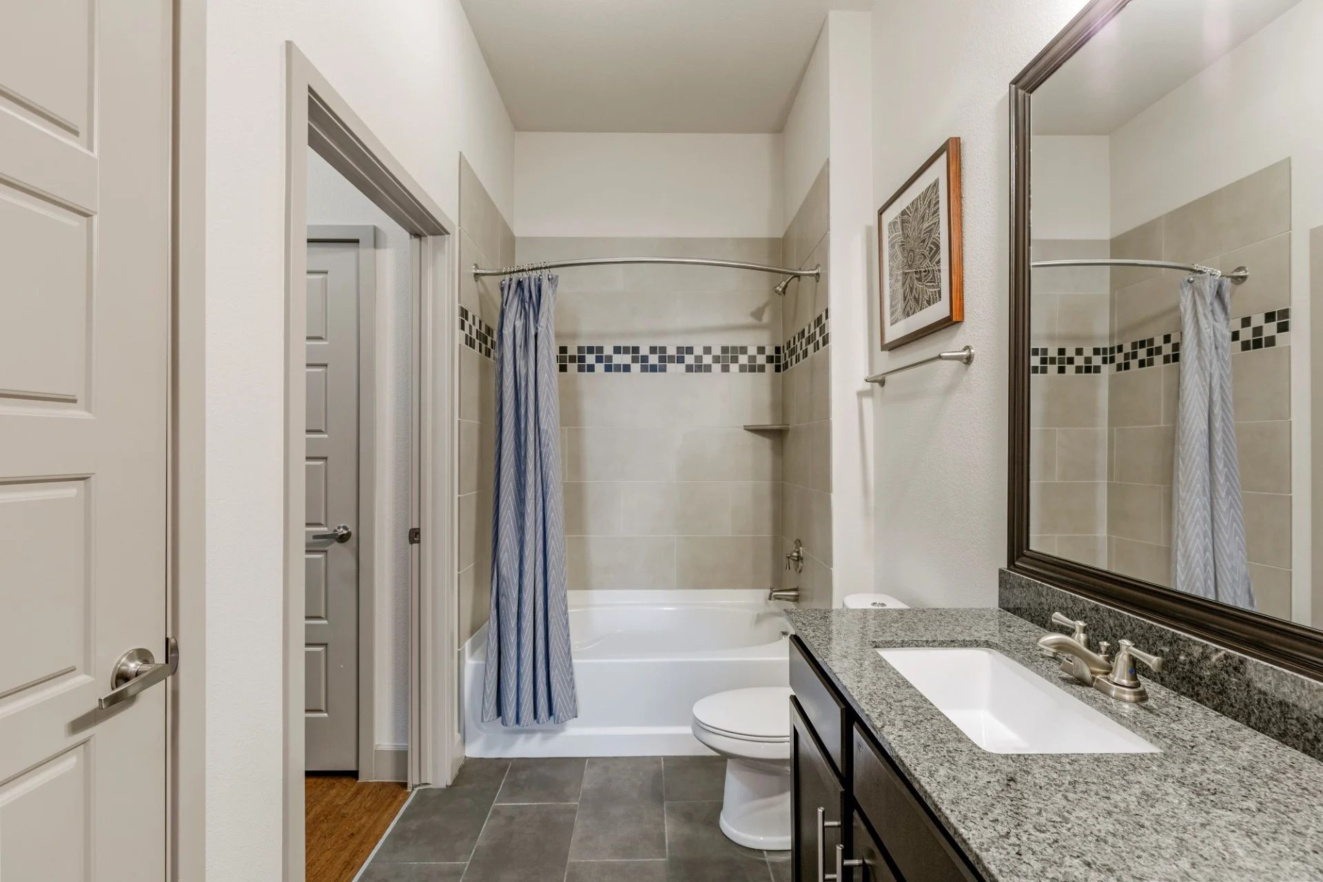 A bathroom with a sink , toilet , bathtub and mirror.