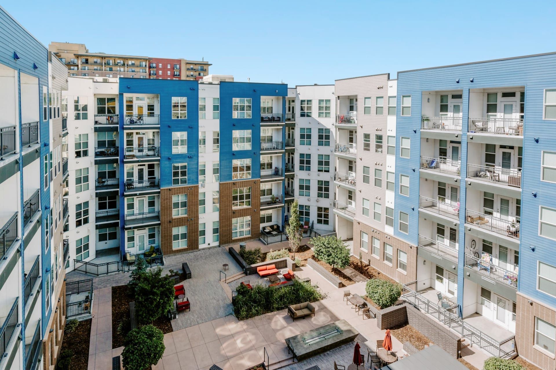 An aerial view of a large apartment building with a courtyard in the middle.