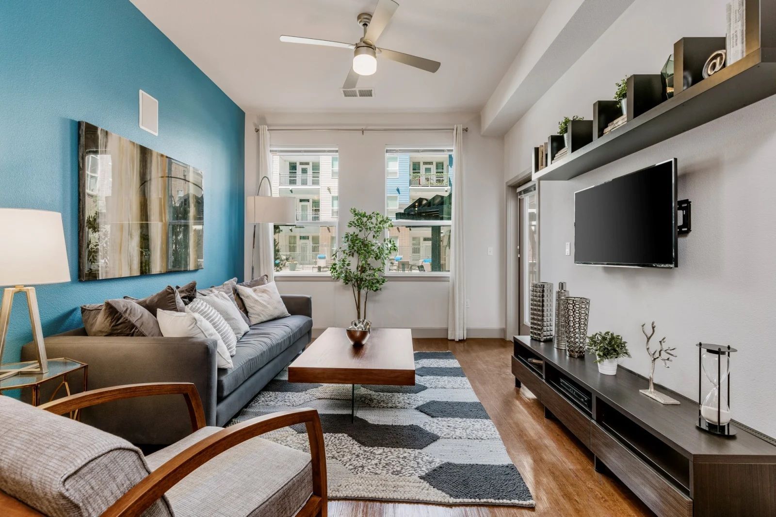 A living room with a couch and a television on the wall