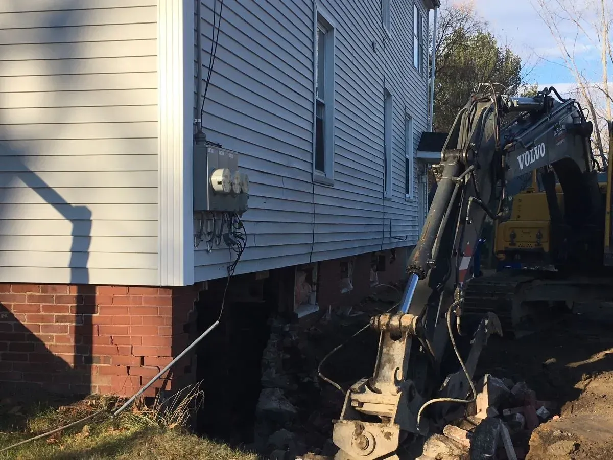 A house is being moved by a volvo excavator.