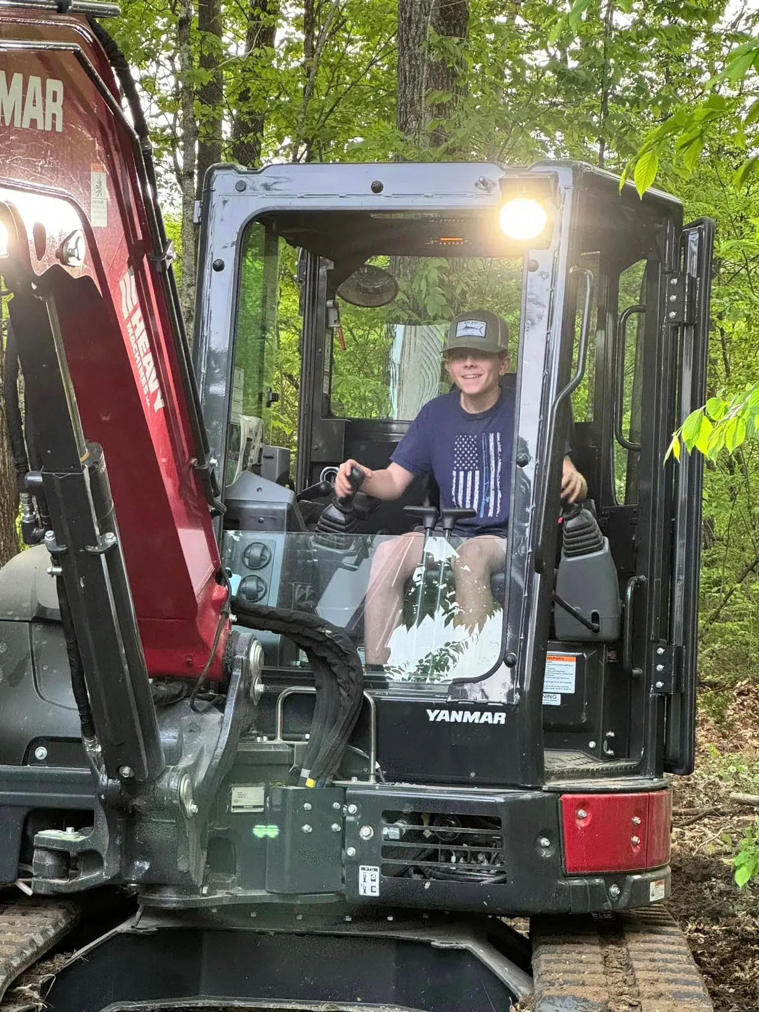 A man is sitting in the driver 's seat of an excavator.