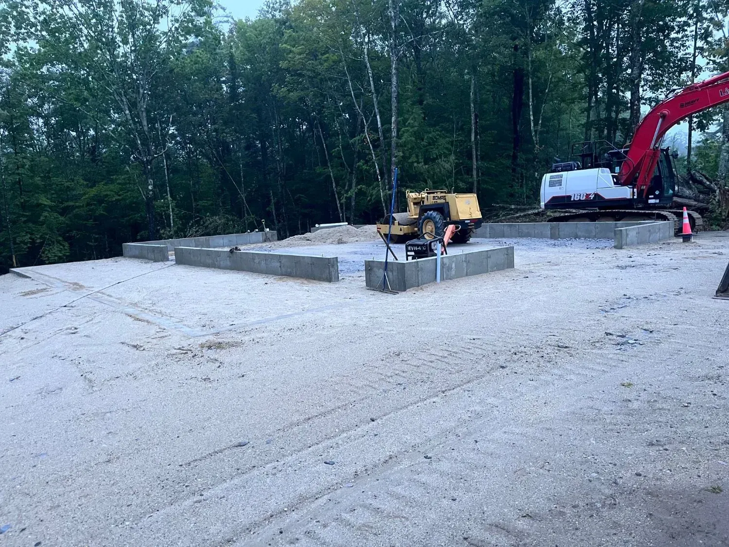 A large excavator is sitting on top of a dirt field.