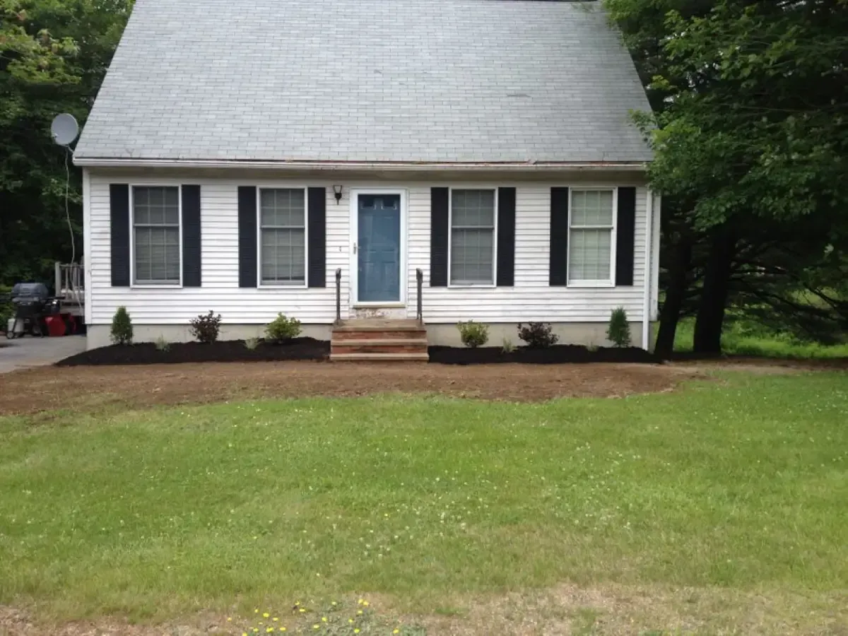 A white house with black shutters and a blue door
