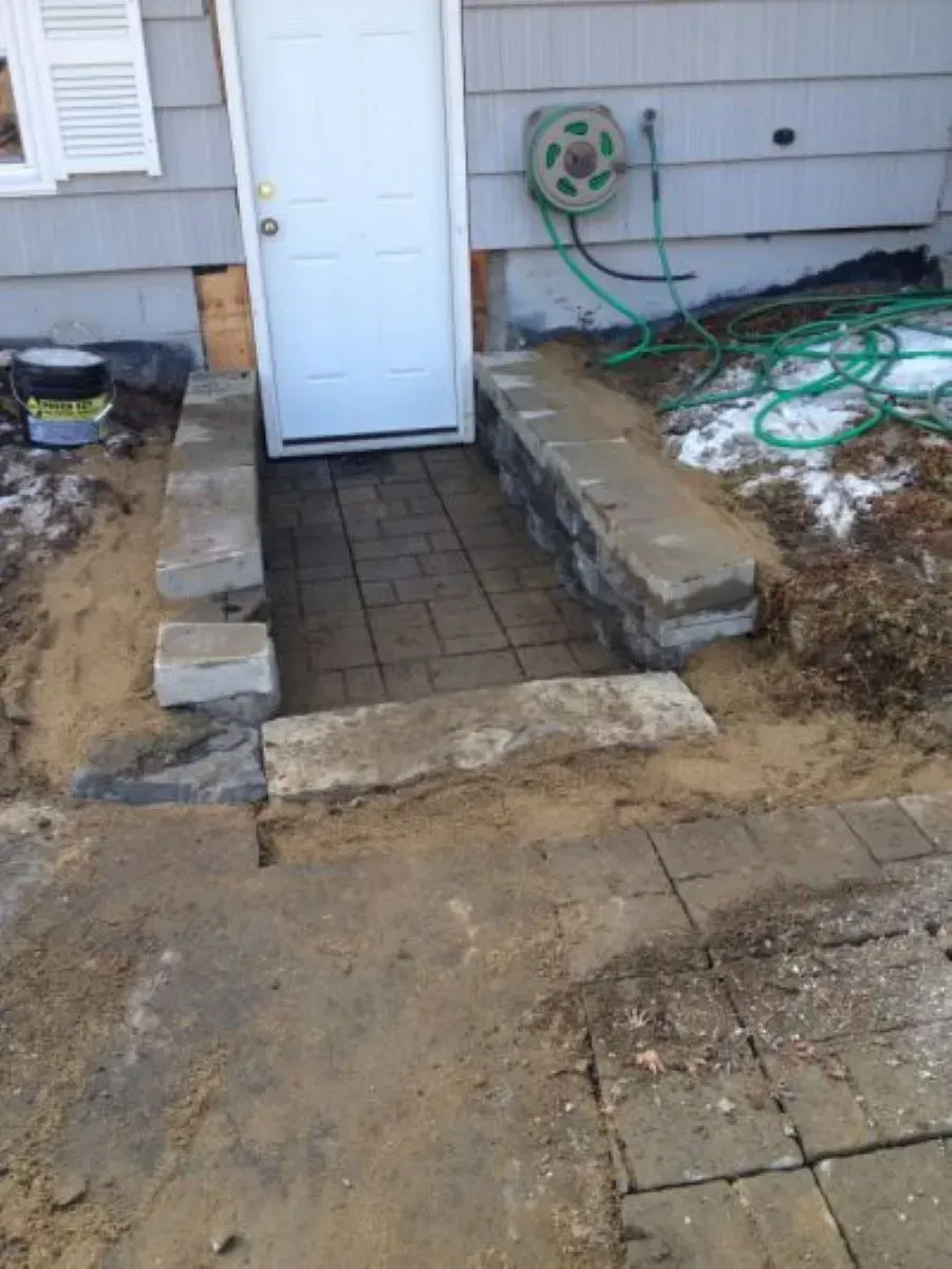 A hose is hanging on the side of a house next to a door.
