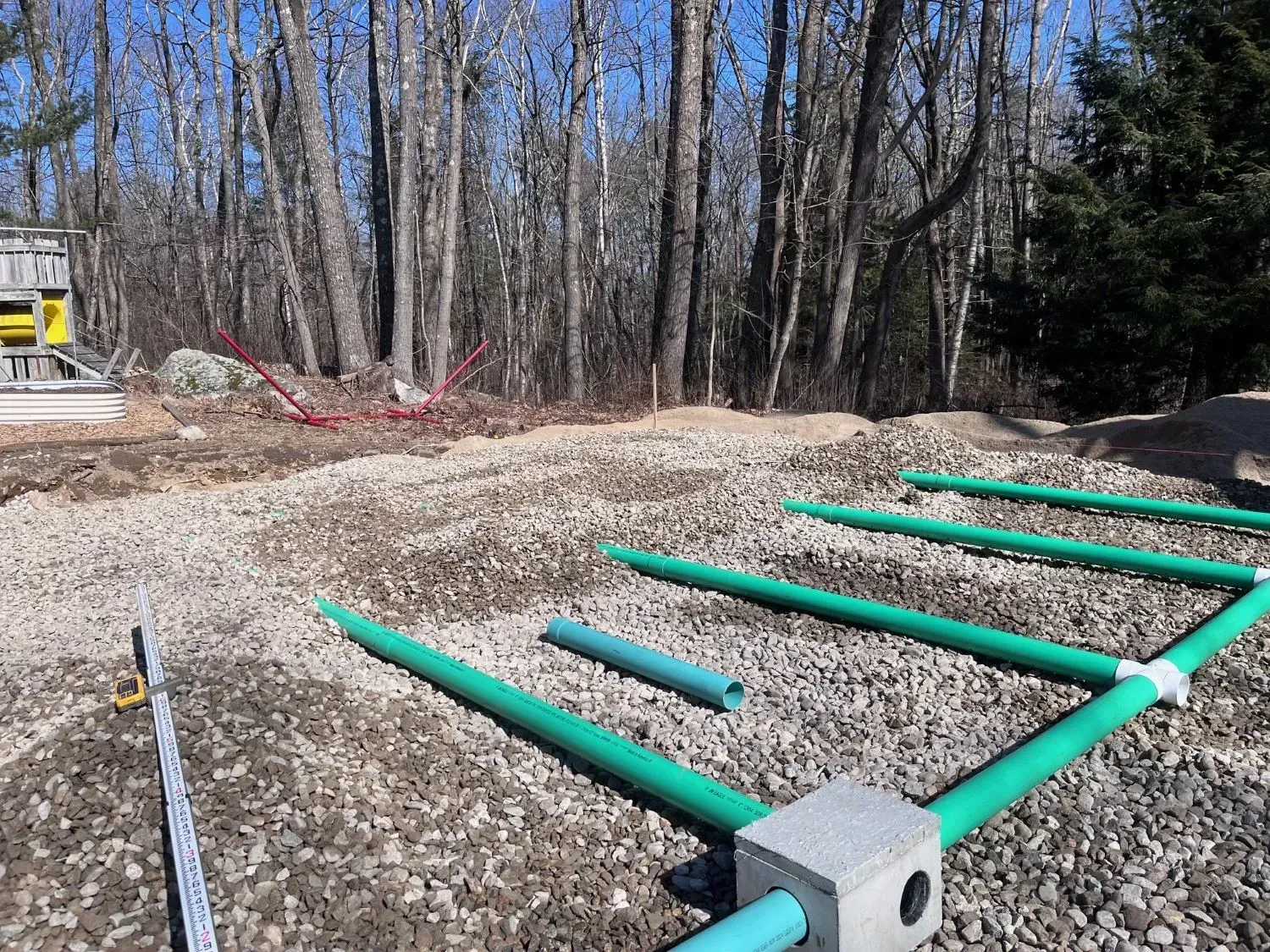 A construction site with a lot of concrete and trees in the background.