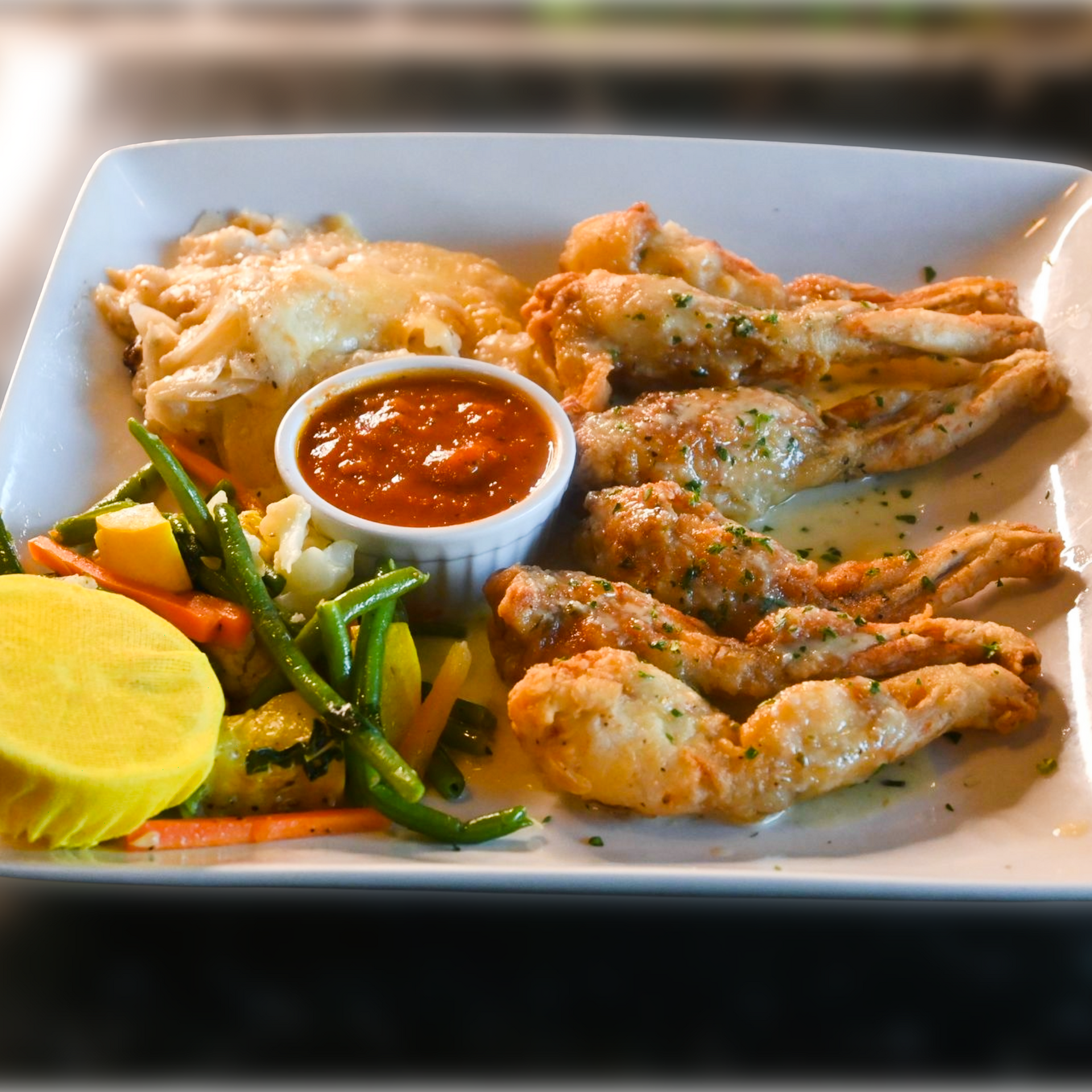 Frog Legs Sauté Provençale served with garlic, parsley, and herbs, plated in classic French bistro style with a golden, aromatic finish.