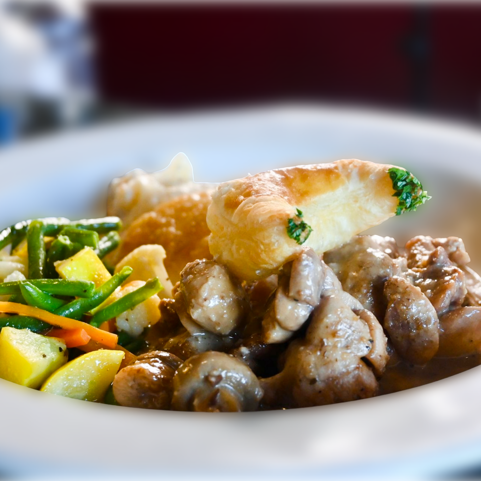 Close-up of a savory entrée plated with sautéed vegetables and tender potatoes, showcasing Chez Pierre Bistro’s French-inspired presentation.