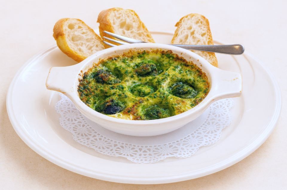 Plate of Burgundy escargots served in garlic and herb butter, presented in a classic French escargot dish with a warm, elegant bistro style.”