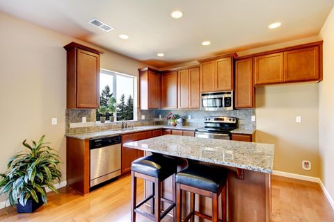 A kitchen with wooden cabinets and granite counter tops