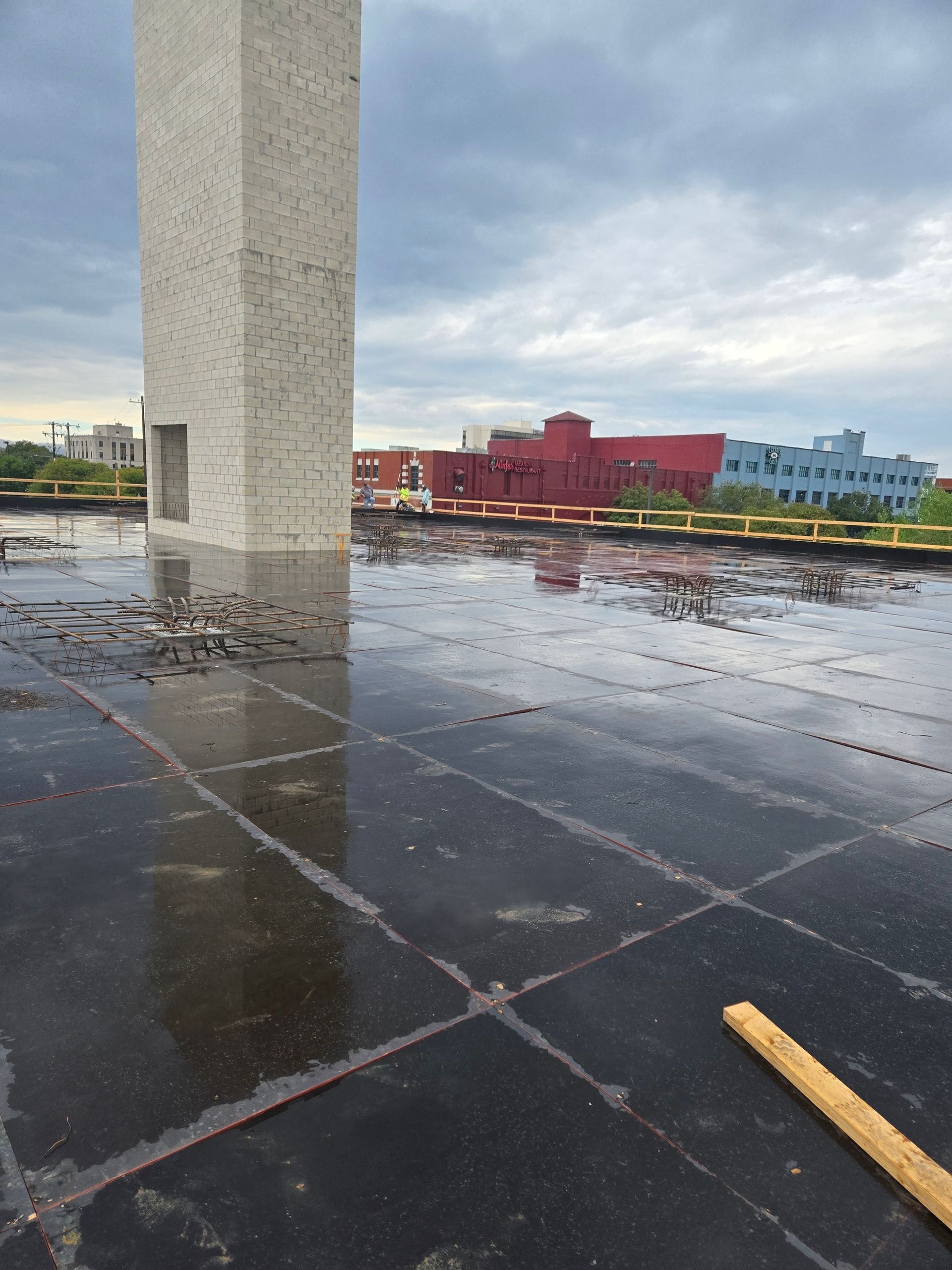 A very wet roof with a tower in the background