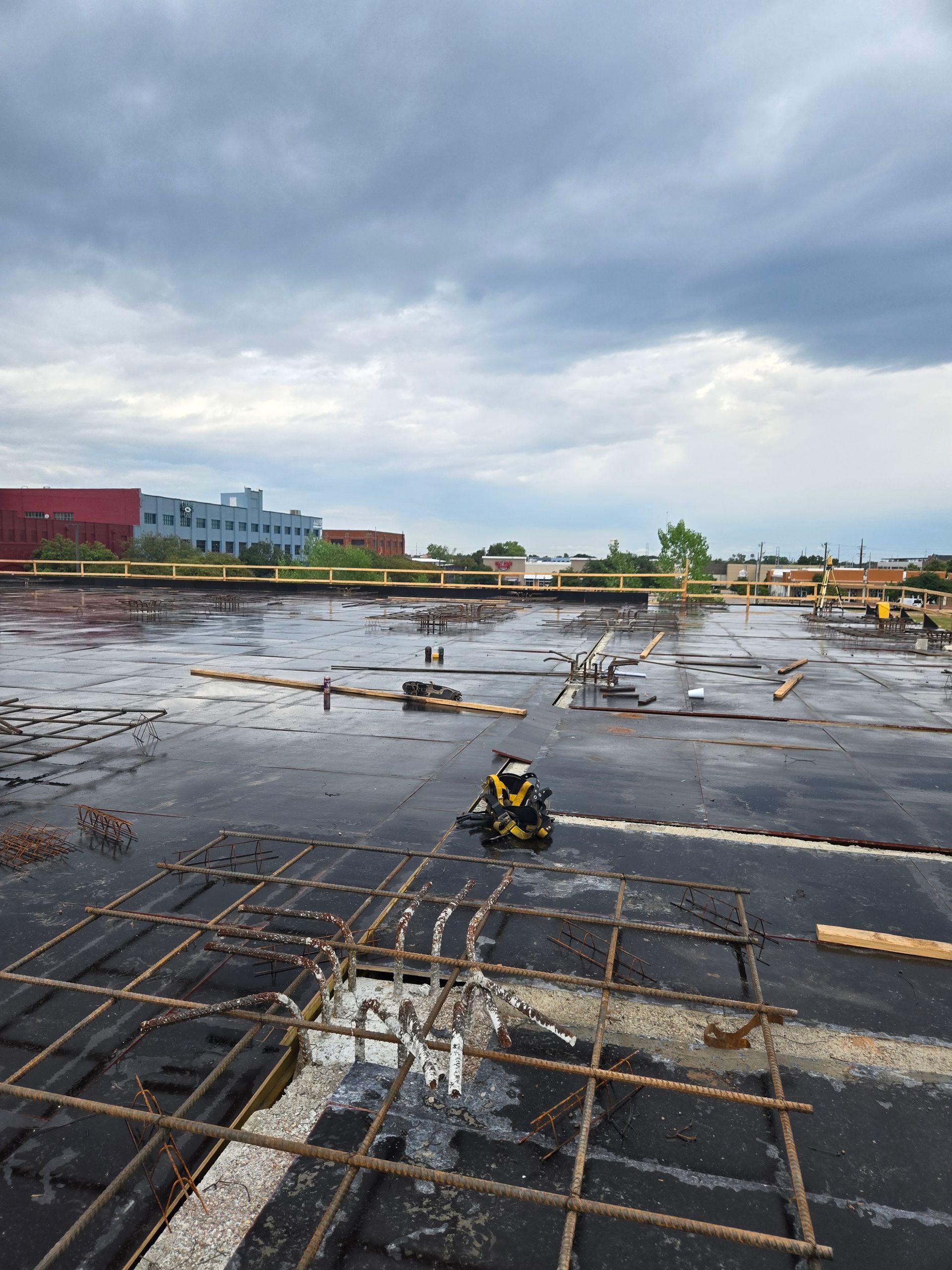 A construction site with a lot of concrete and a building in the background.