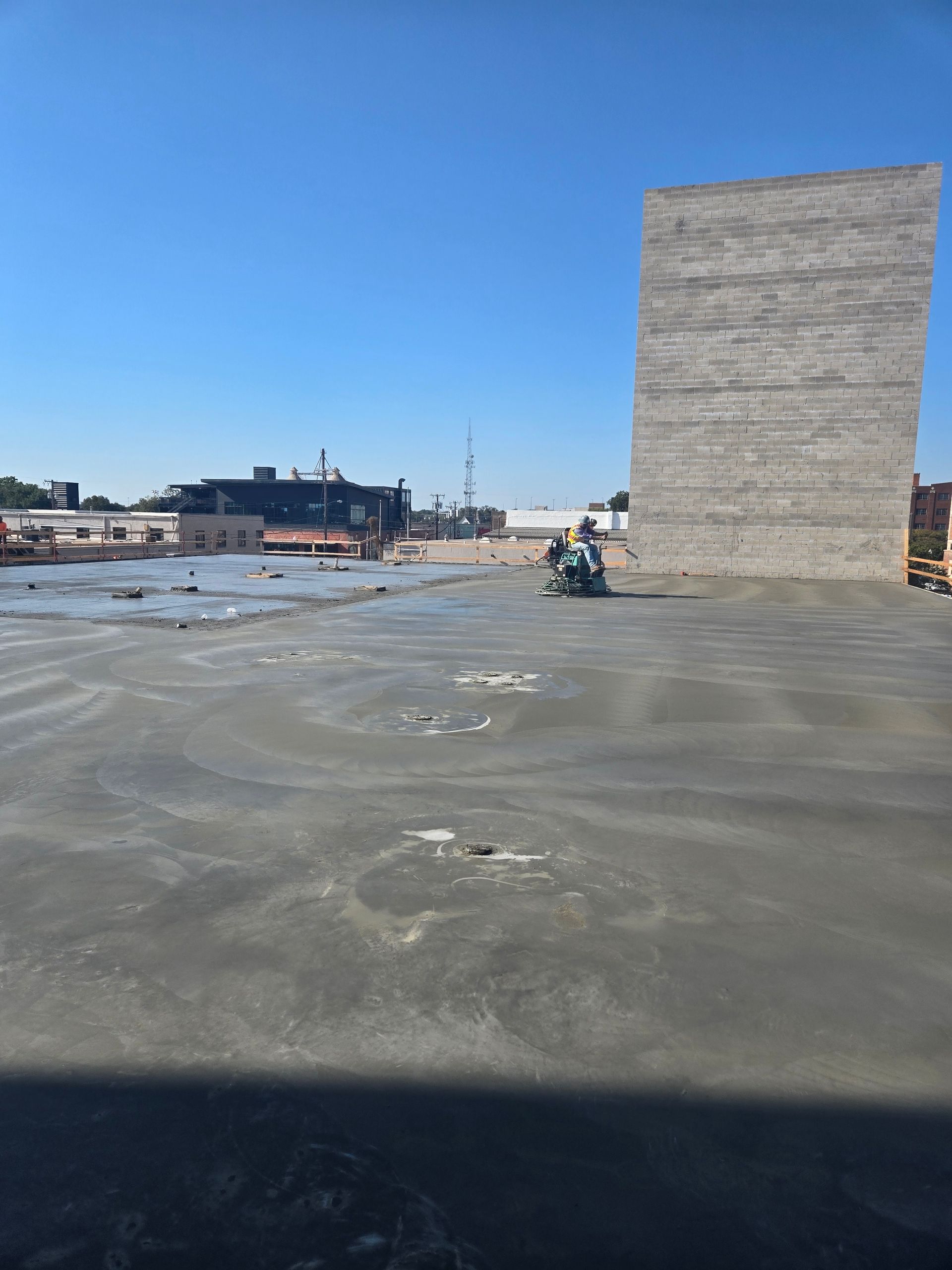 A construction site with a large concrete wall in the background