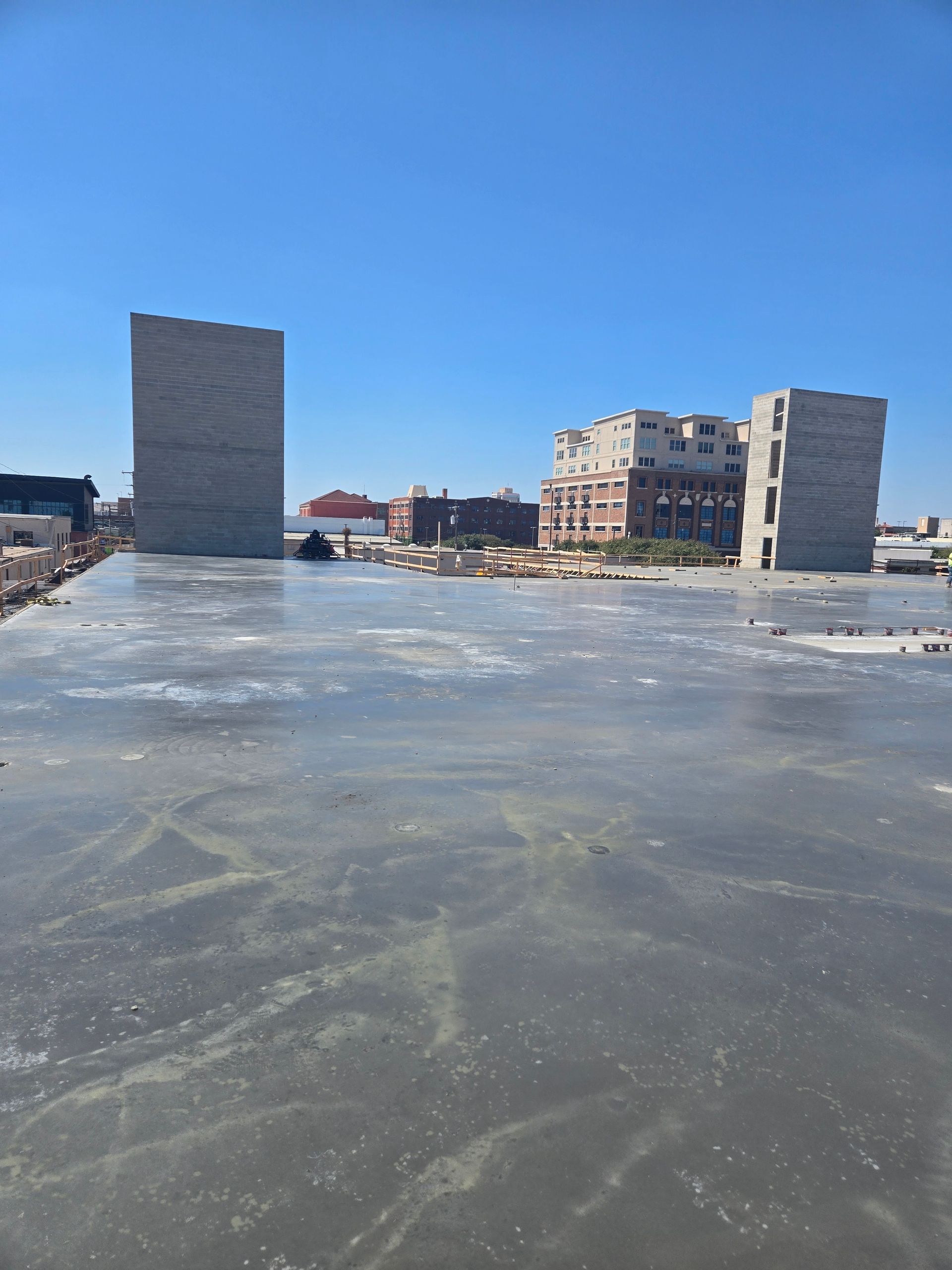 A construction site with a lot of concrete and buildings in the background