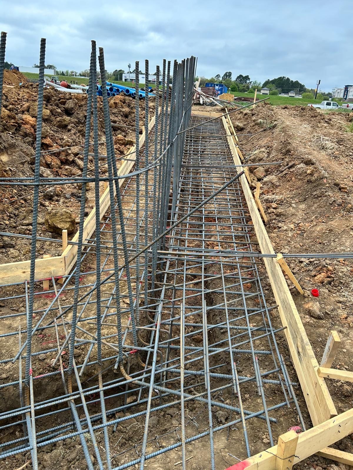 Steel rebar framework in an excavated trench at a construction site
