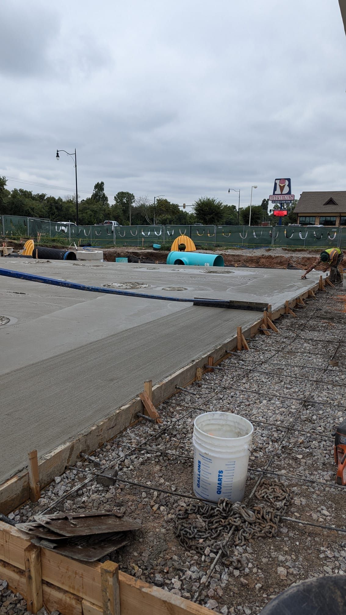 A bucket of concrete is sitting on the ground in a construction site.