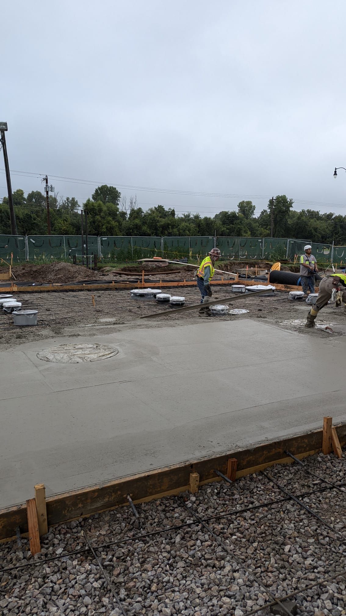 A group of construction workers are pouring concrete on a construction site.