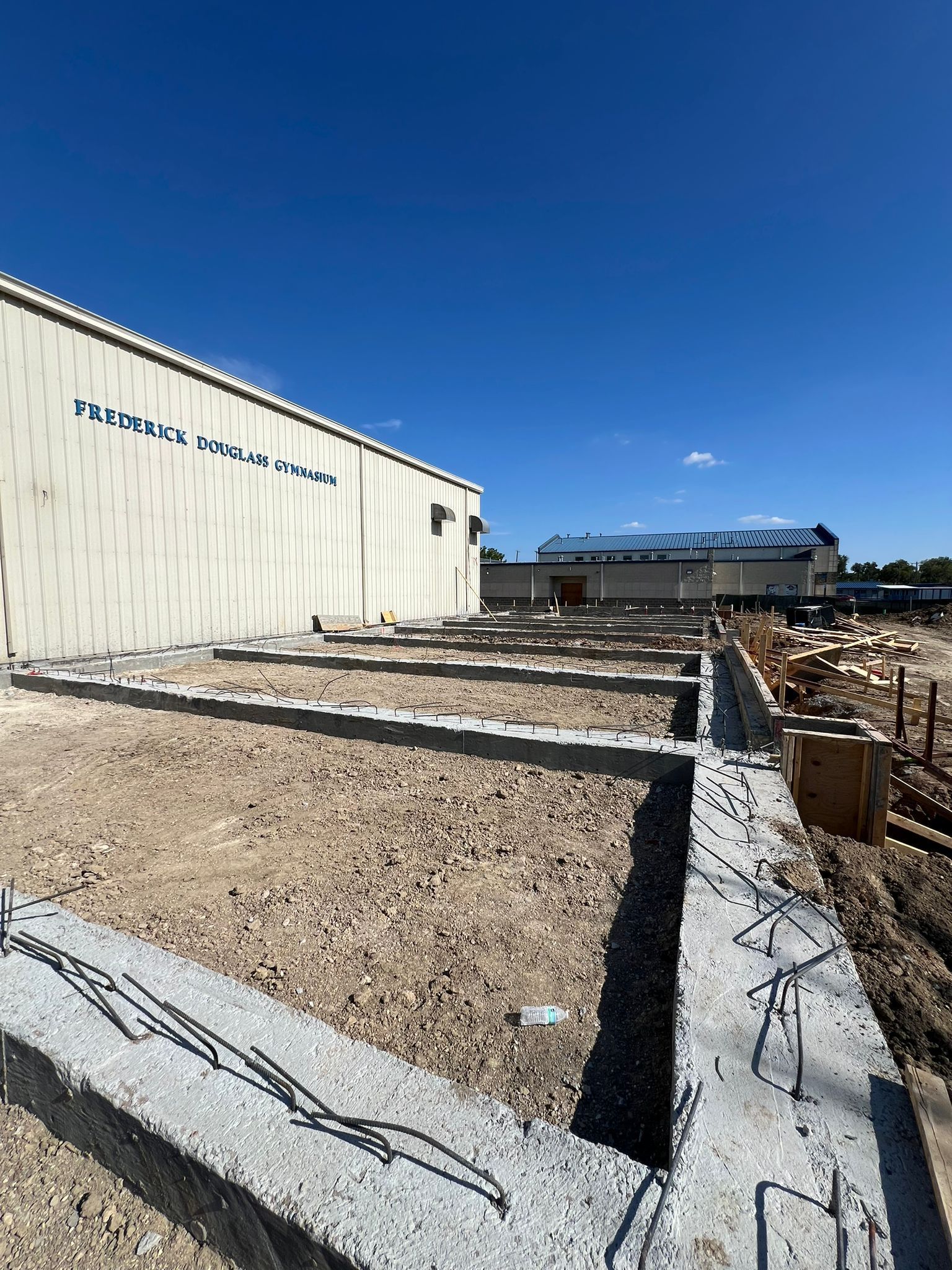 A building under construction with a lot of dirt in front of it.