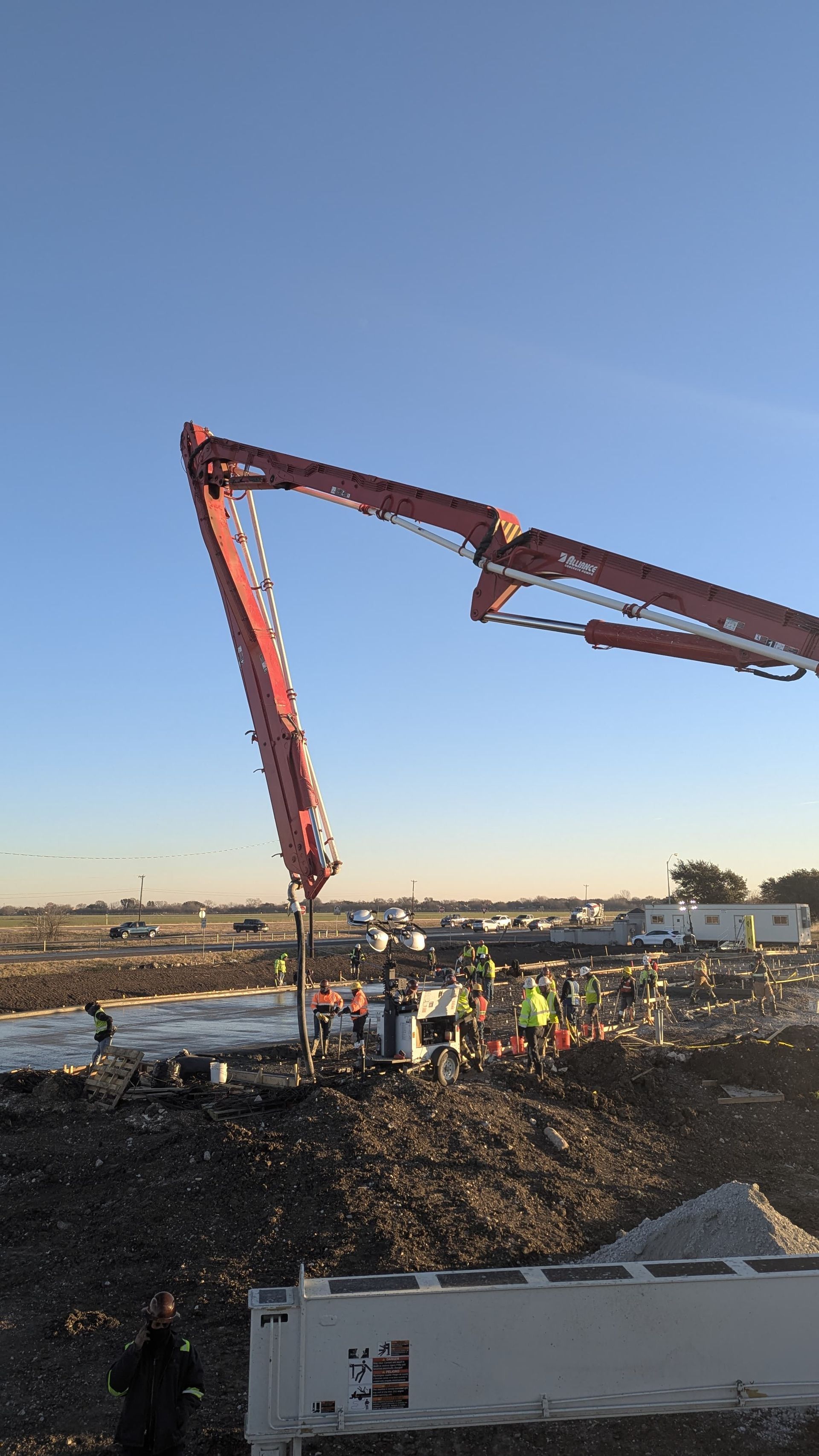 A concrete pump is being used to pour concrete on a construction site.