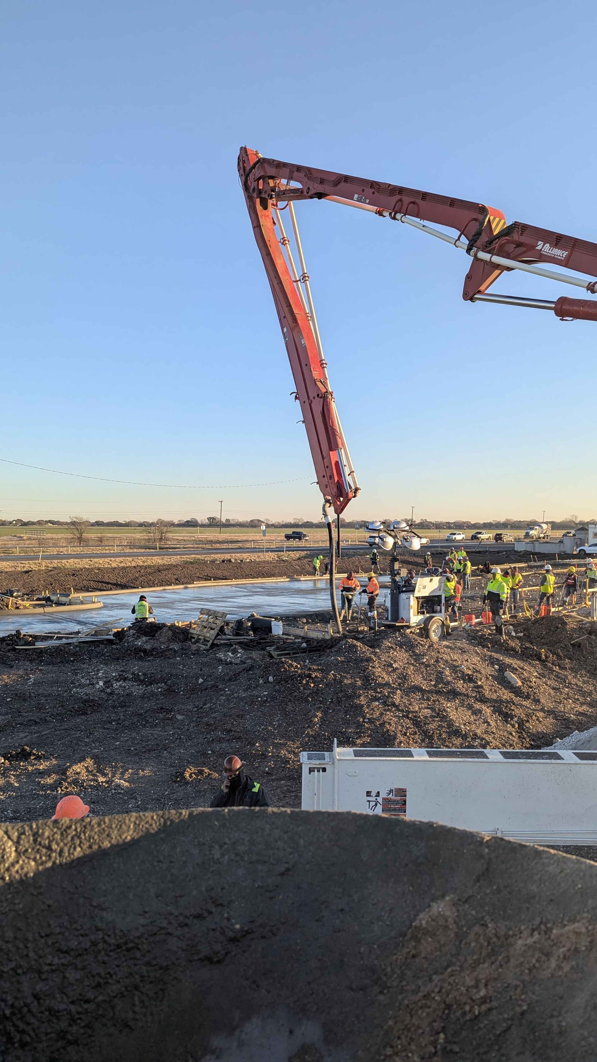 A concrete pump is being used to pour concrete on a construction site.