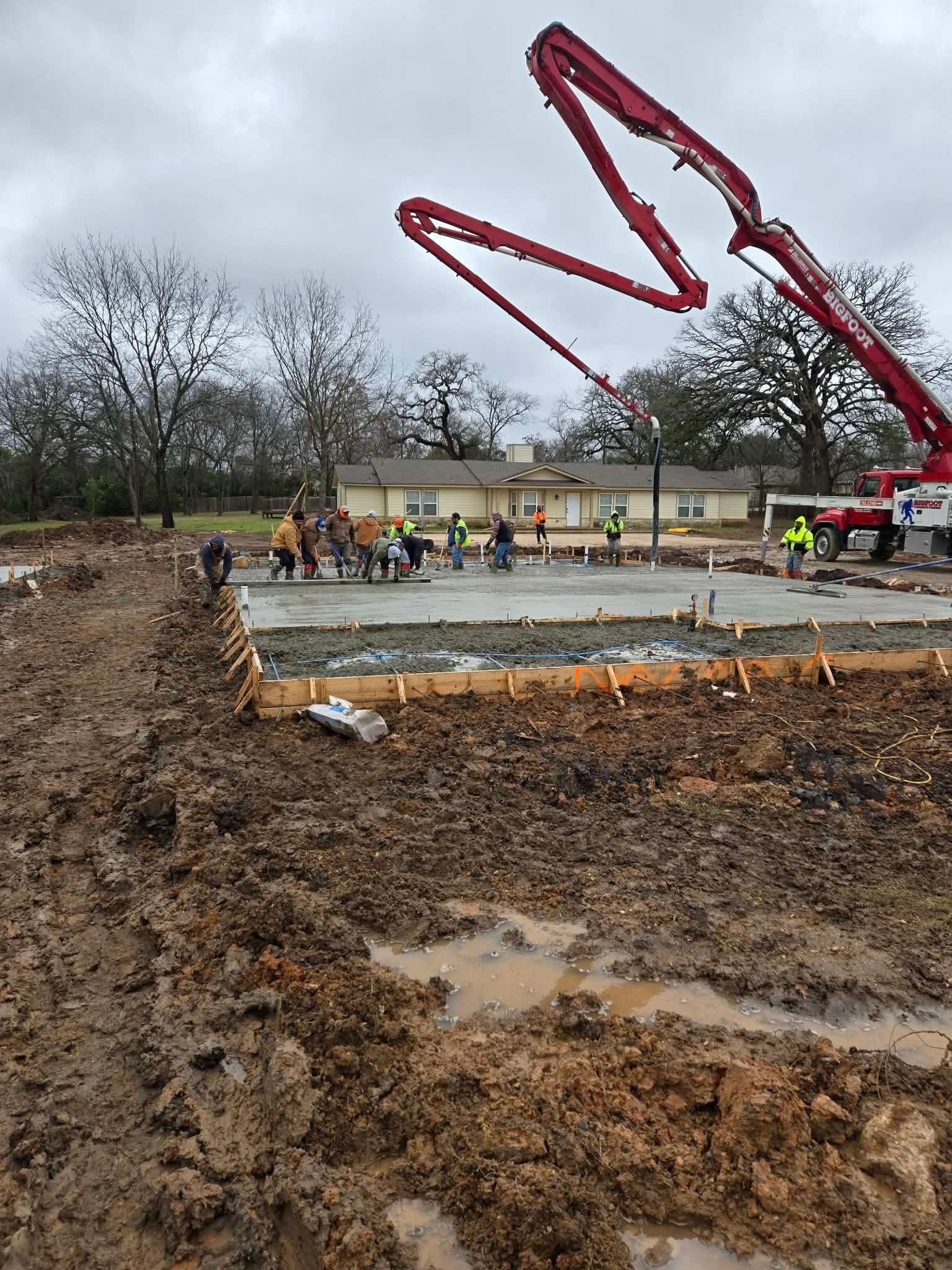 A group of construction workers are working on a dirt field.