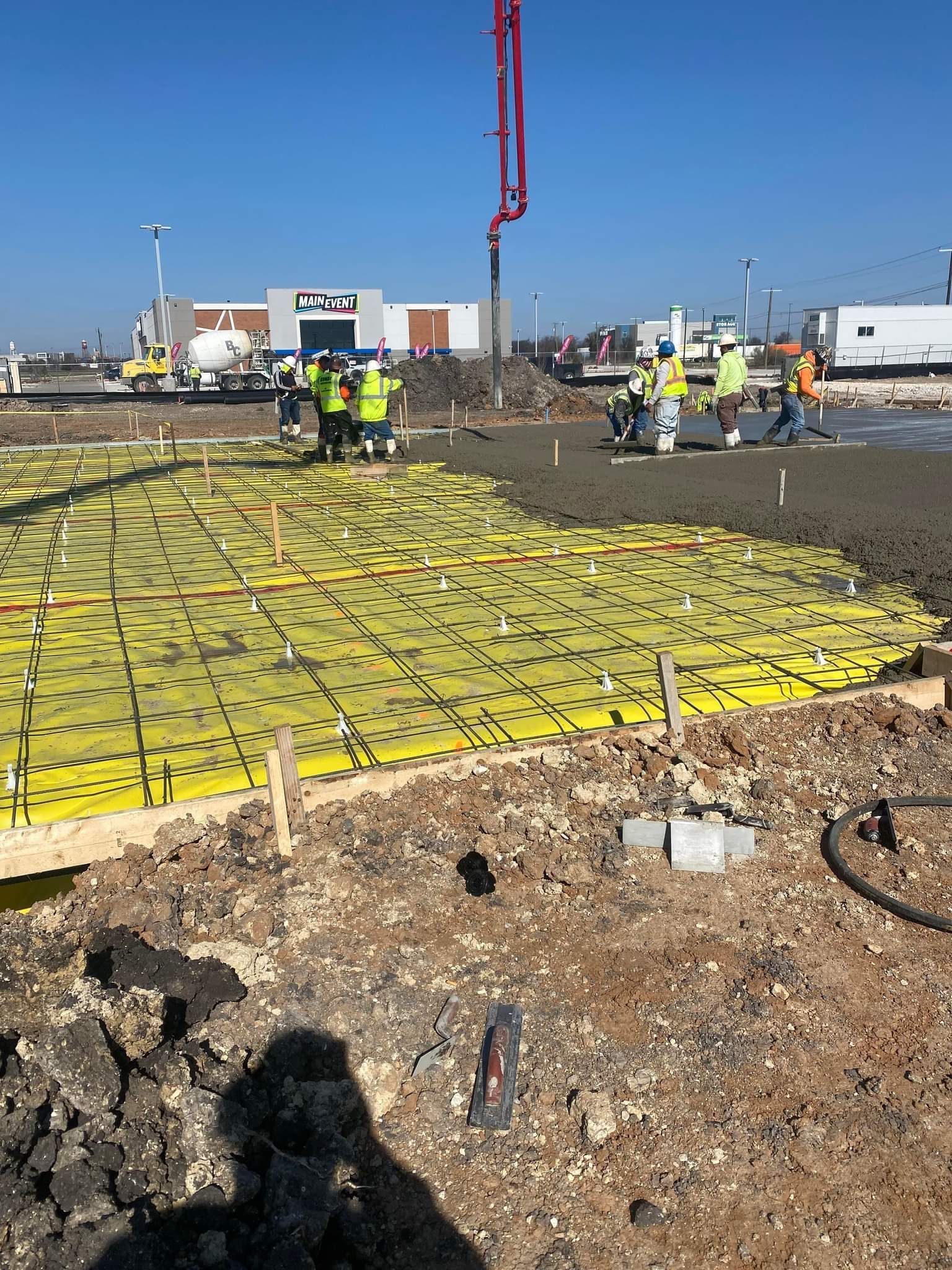 A group of construction workers are working on a concrete floor.