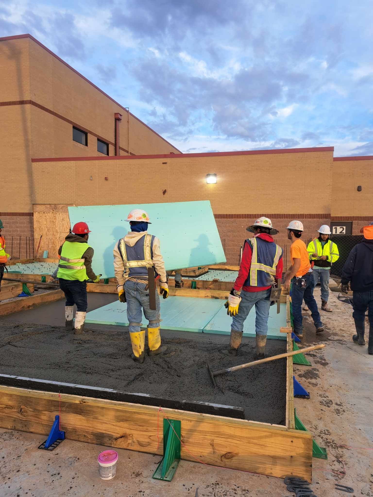 A group of construction workers are standing in front of a building.