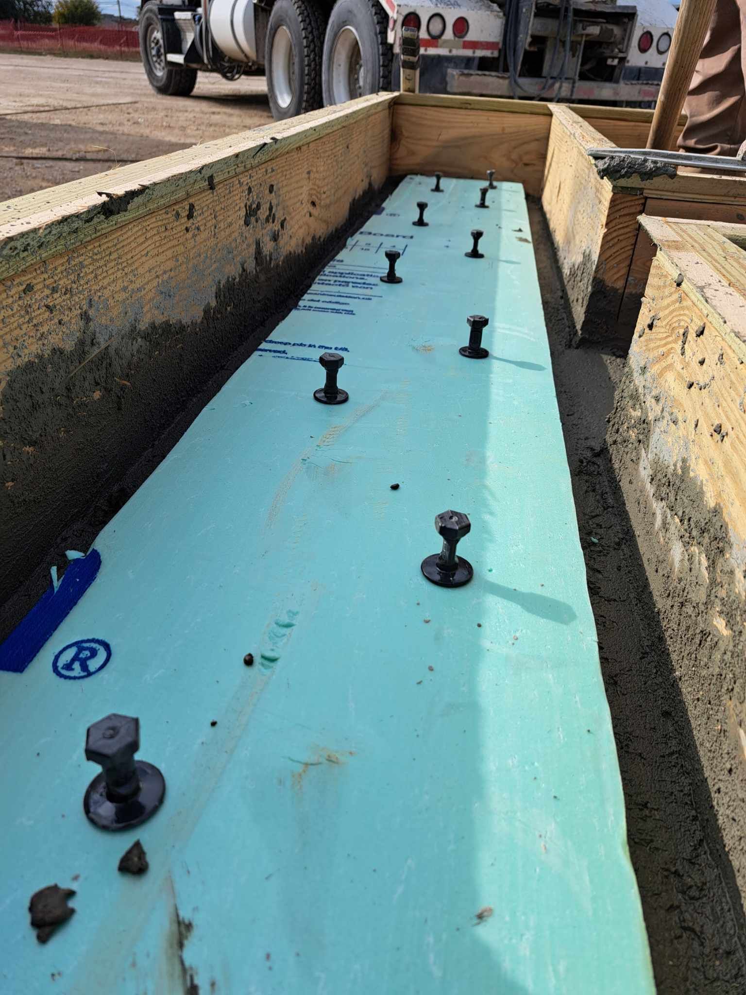 A truck is parked in the background of a construction site.