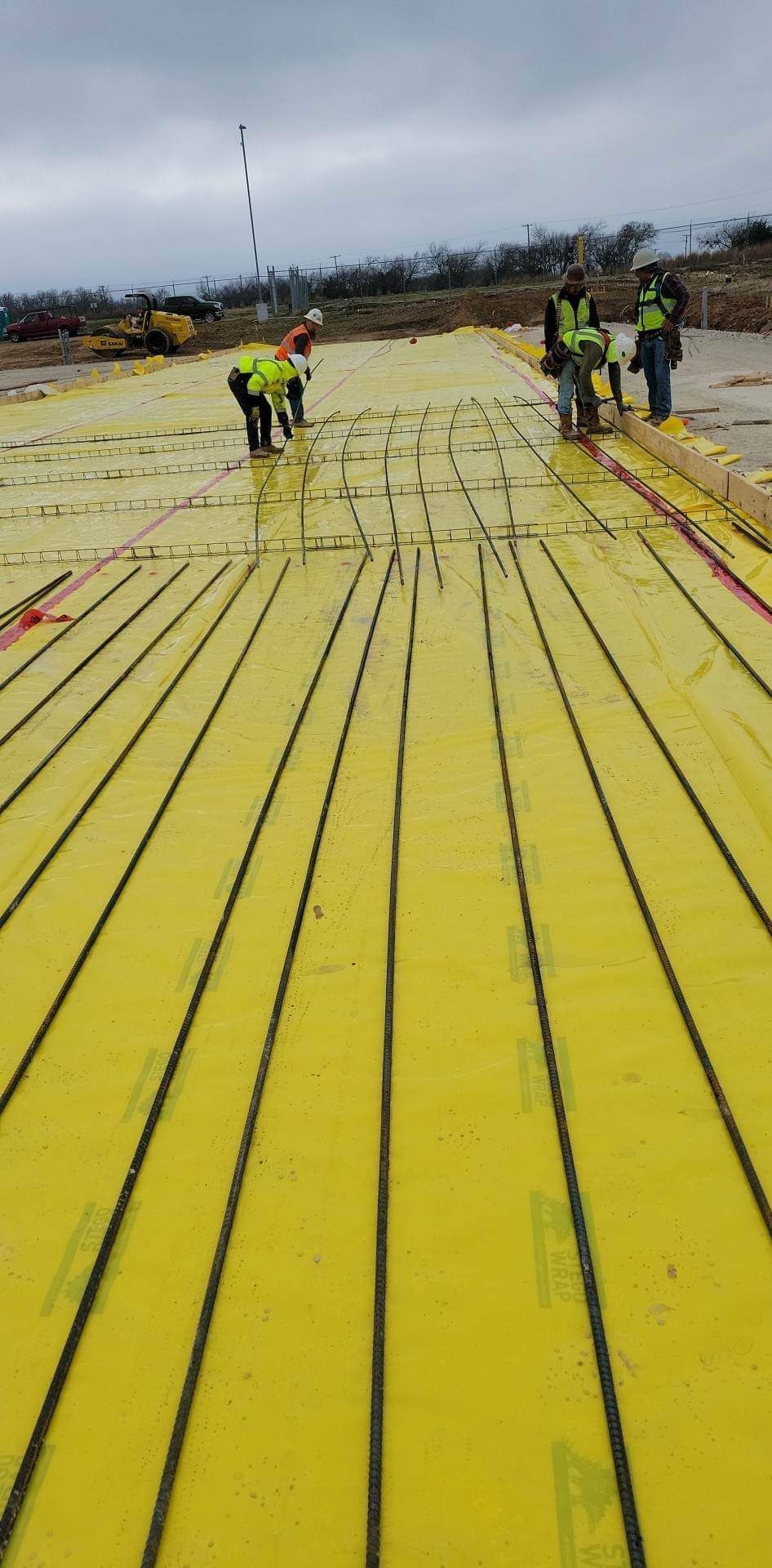 A group of construction workers are working on a yellow roof.