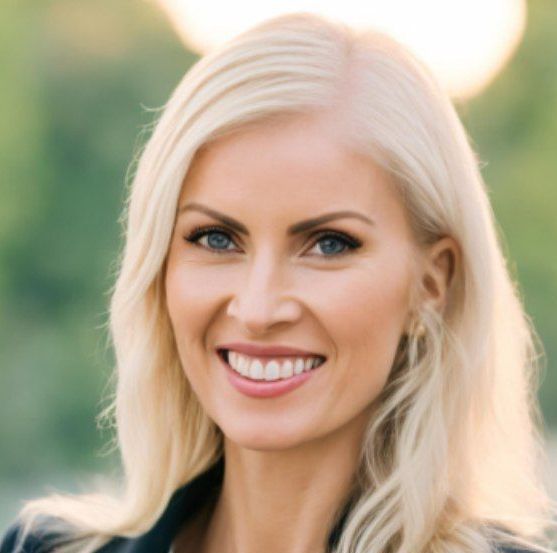 a woman with blonde hair and blue eyes smiles for the camera