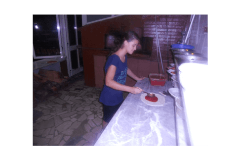 pizzaiolo versa la salsa di pomodoro sull'impasto