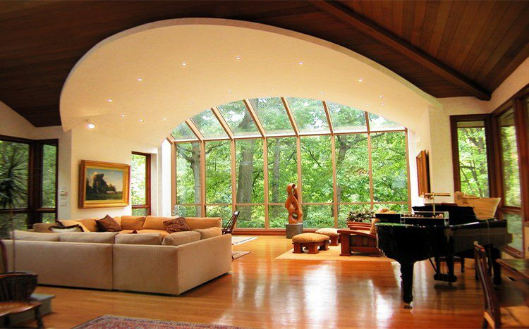 A living room with a piano and lots of windows