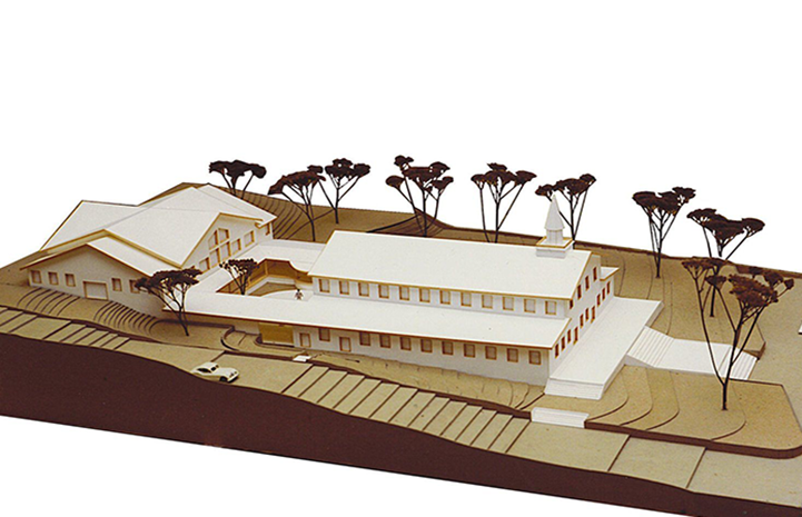A model of a building with trees in the background