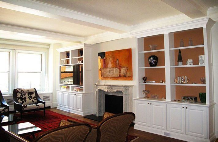 A living room with a fireplace and lots of shelves