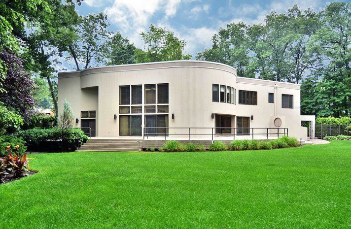 A large white house with a lush green lawn in front of it