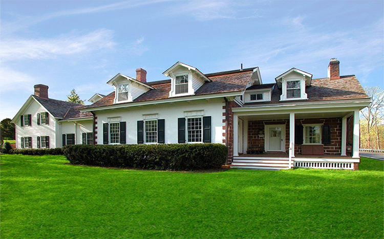 A large white house with black shutters and a porch