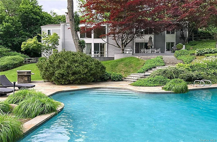 A large swimming pool in front of a house