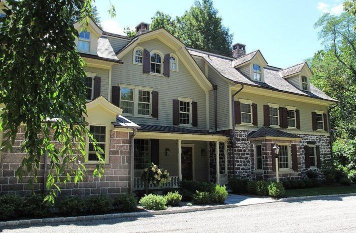 A large brick house with a porch and shutters