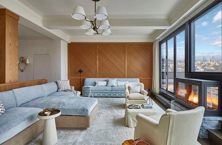 A living room with a couch , chairs , and a fireplace.