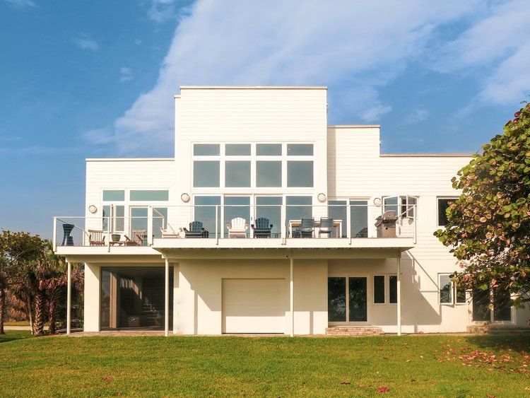 A large white house with a lot of windows and a balcony