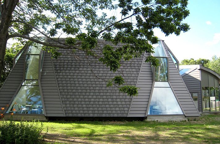 A house with a pyramid shaped roof and a lot of windows