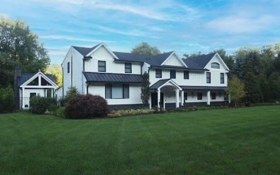 A large white house with a large deck in front of it