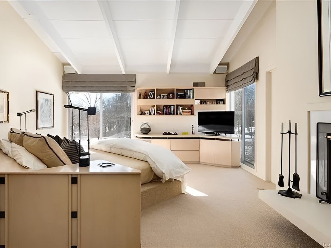 A bedroom with a large bed and a fireplace