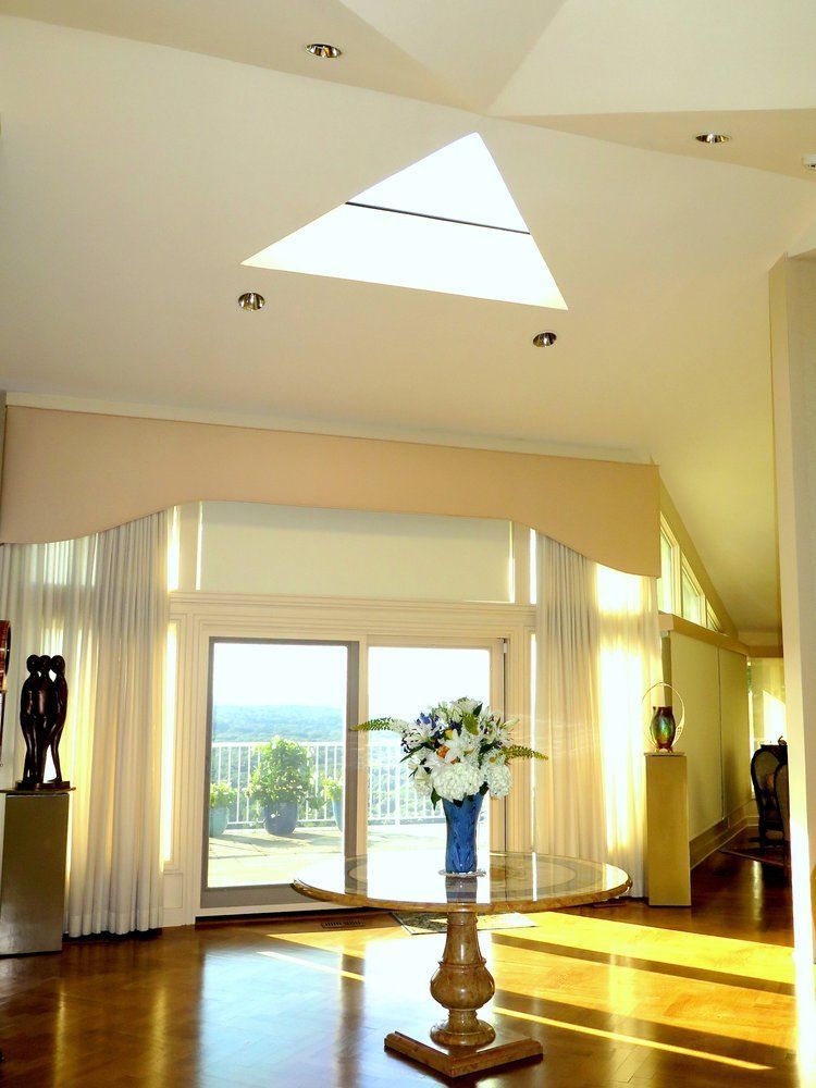 A living room with a skylight and a table with flowers on it