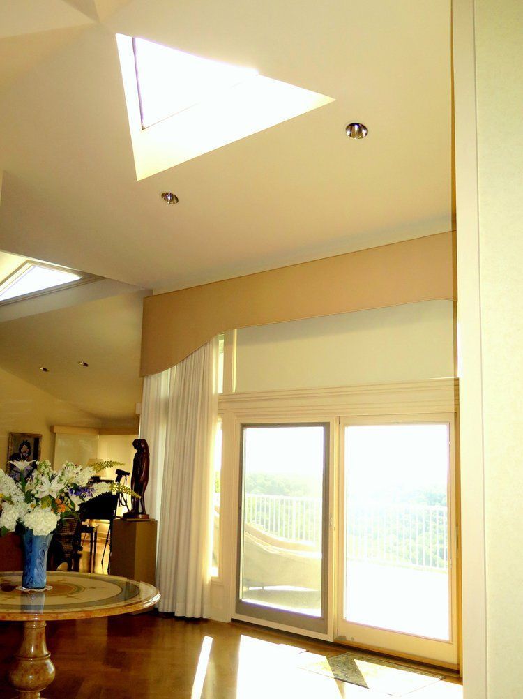 A living room with a skylight and sliding glass doors