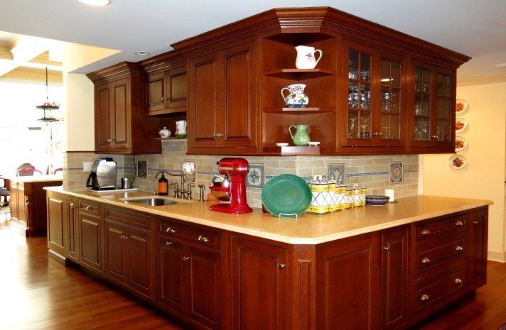 A kitchen with wooden cabinets and a red mixer