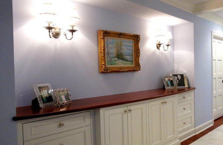 A hallway with white cabinets and a picture on the wall