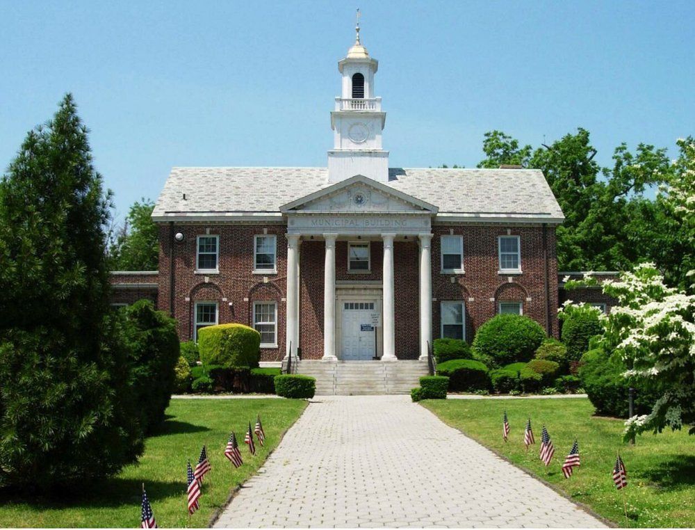 A large brick building with columns and a clock tower