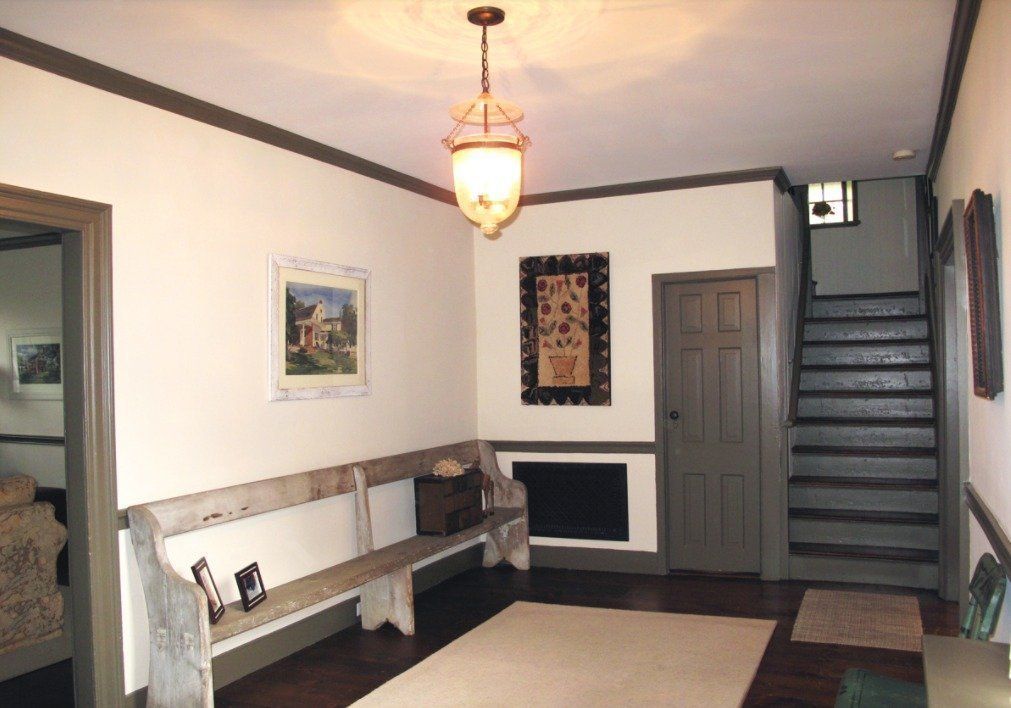A hallway with stairs leading up to the second floor