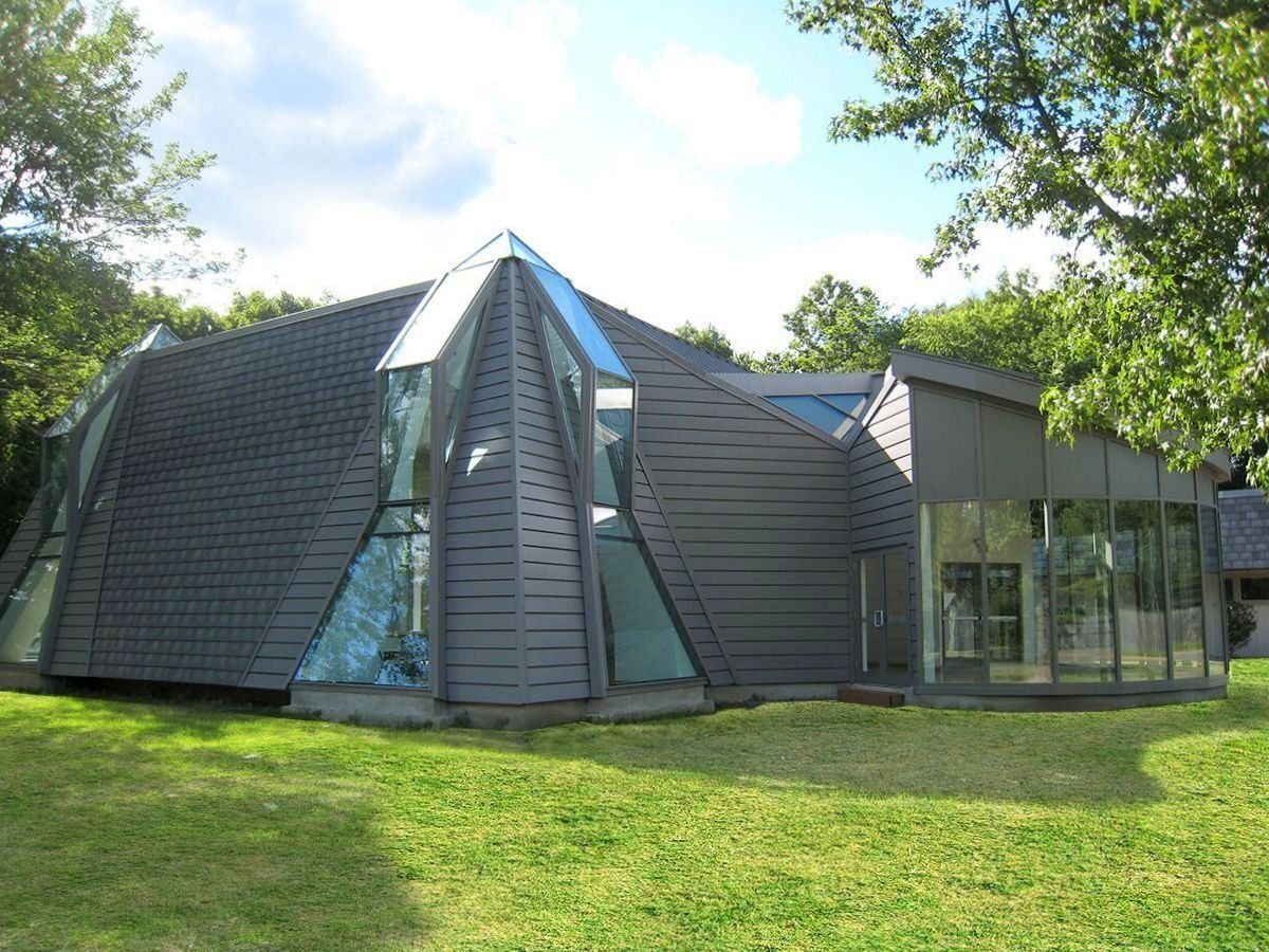 A house with a pyramid shaped roof and a lot of windows